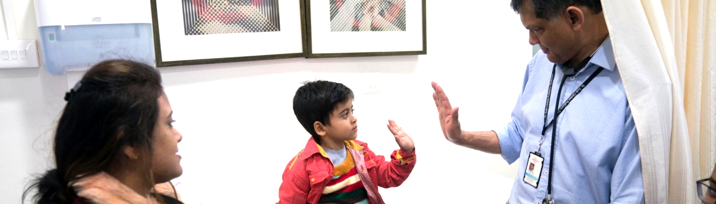 Professor Vaskar Saha high-fiving a child.