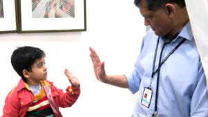Professor Vaskar Saha high-fiving a child.