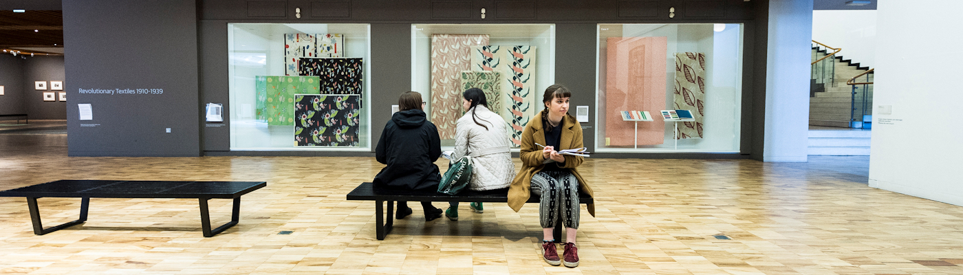 People sitting in a gallery viewing the artworks.