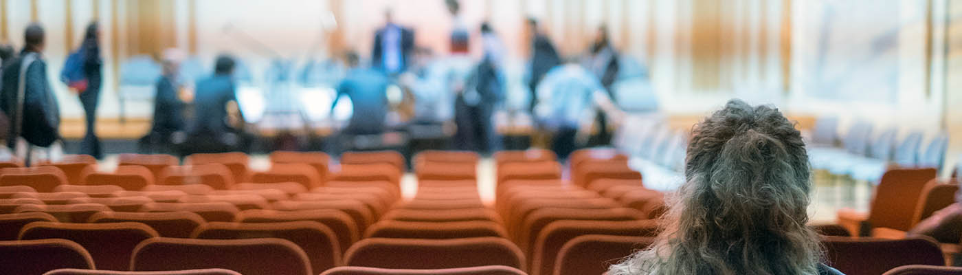 A person waits for a performance to begin at the Martin Harris Centre for Music and Drama.