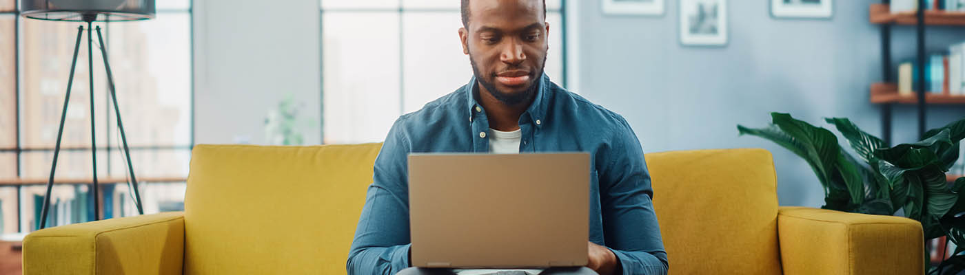 Handsome,Black,African,American,Man,Working,On,Laptop,Computer,While A person reading online news on their laptop.